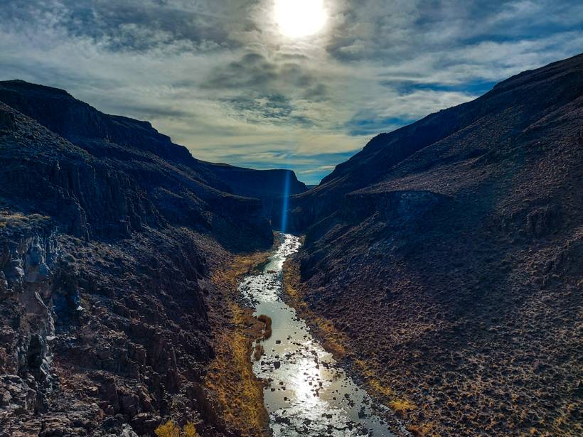 Un río que serpentea en el fondo de un cañadón, visto desde arriba